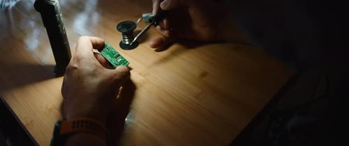 Hands Soldering Electronic Component on Printed Circuit Board