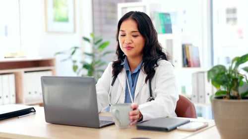 Female Doctor Working on Laptop in Bright Office
