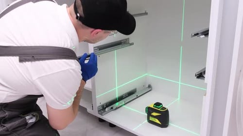 Man Installs Cabinet Rails With Laser Level