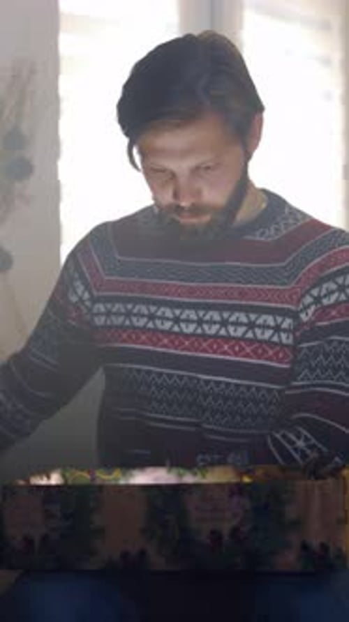 Man Anxiously Uncovers Present in Soft Shadows Silent Anticipation As Man Opens Hidden Gift Amidst