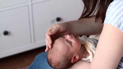 Newborn Sleeps in Woman's Arms