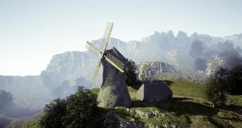 Historic Windmill on Hillside Overlooks Mountains in Morning Light