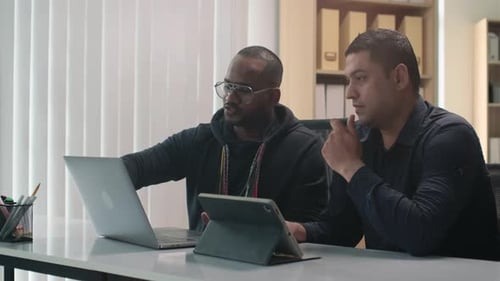 Men Discussing Project on Laptop in Office