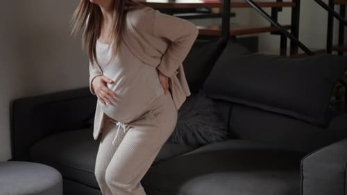 Pregnant Woman with Back Pain Resting on Couch
