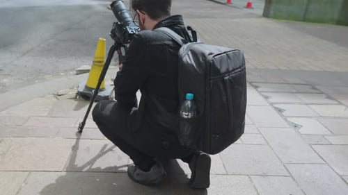 Photographer Crouches Taking Pictures in the City