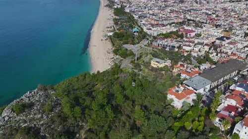Aerial Video of a Funicular Moving Through a Lush Green Landscape While Overlooking the City and the