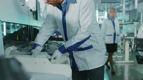 Hightech-Fabrik: Der Inspektor für die Qualitätskontrolle nimmt die Elektronisch Leiterplatte in die Hand und überprüft sie