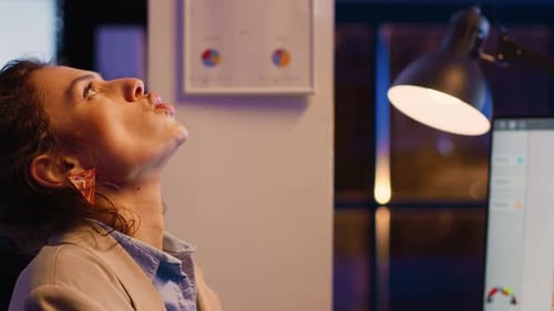 Frustrated Person Sitting in Office Late at Night