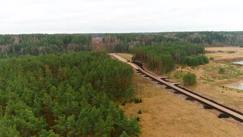 Freshly build gravel road in woodland area, aerial drone view
