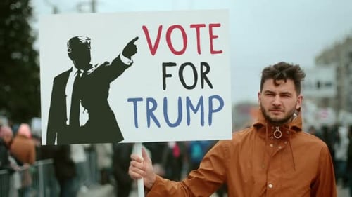 Man Holds Political Sign at Outdoor Rally