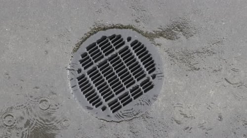 Rainwater Draining Into Sewage Drainage On The Ground Outdoor. close up