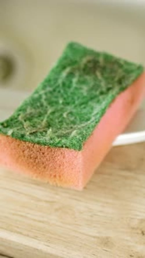Vertical shot of a dirty sponge on the sink in the kitchen at home, household, zoom out close up
