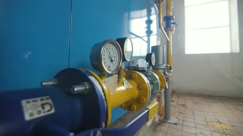 Industrial Pipes and Pressure Gauges on Blue Wall