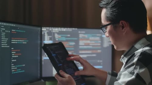 Gros plan d'un programmeur regardant la base de données sur une tablette tout en créant une Appli de développement d'un ingénieur logiciel