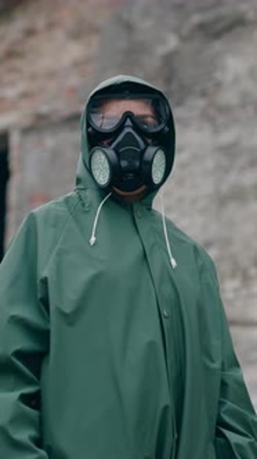 Person in Gas Mask Stands in Ruined City