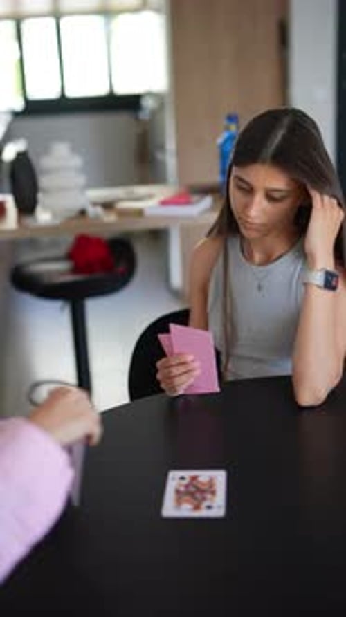 Two People at Home Playing a Card Game Focusing on Competition and Enjoying Leisure Time Together