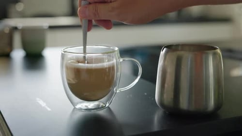 Stirring Sugar into Hot Beverage in Glass Cup