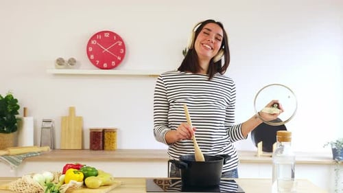 Young Woman Cooking and Dancing in Bright Kitchen