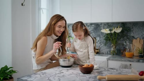 Woman and girl baking together in kitchen