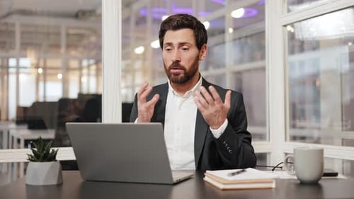 Businessman in Suit Having Video Conference on Laptop in Modern Office