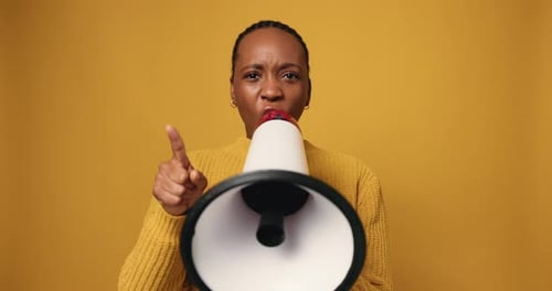 Megaphone, shouting and face of black woman in studio for protest, democracy