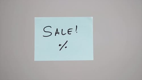 Hand Writes Sale Note on the Wall