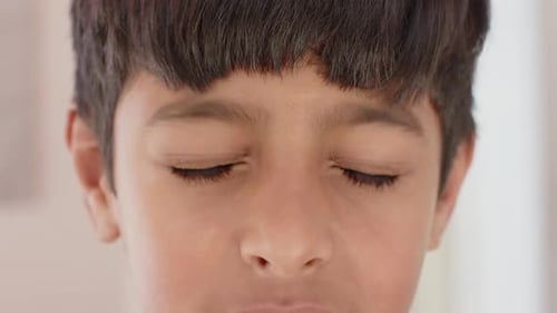 Close-up of young boy looking directly at camera with serious expression