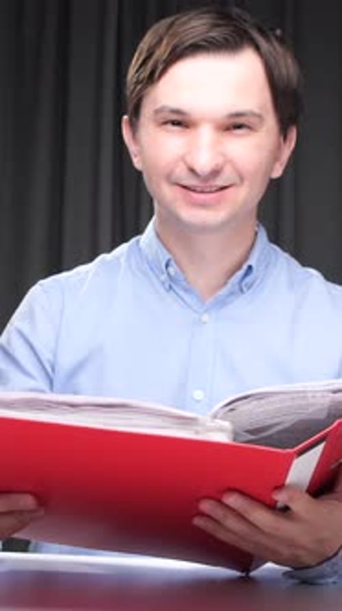 Vidéo verticale : comptable souriant et examinant des documents dans un dossier la nuit