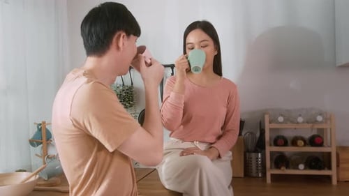 Couple Drinking Coffee and Chatting in Kitchen