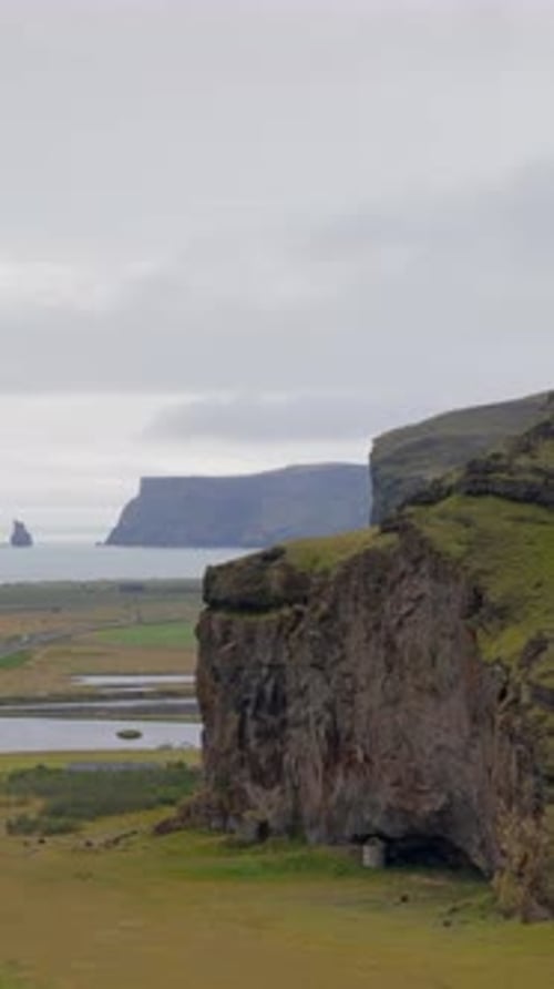 Majestic View of the Icelandic Coastline Featuring Rocky Cliffs and Distant Ocean