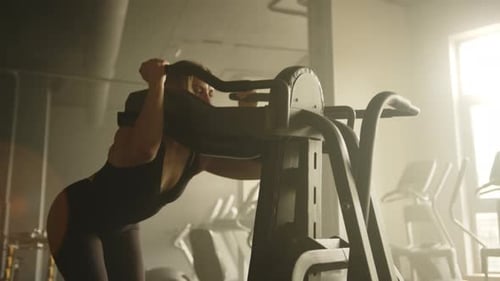 Young Fit Woman Performing Squats on Multifunctional Training Machine in Gym