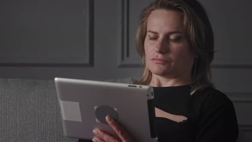 Woman Scrolling on Tablet Device Indoors