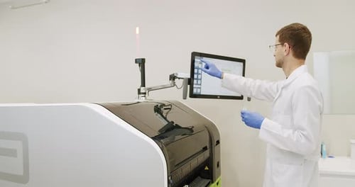 Scientist Operates High-Tech Medical Equipment in Lab