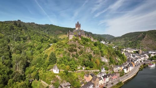 Aerial footage flying toward Reichsburg Cochem, a medieval hilltop castle overlooking the historic t