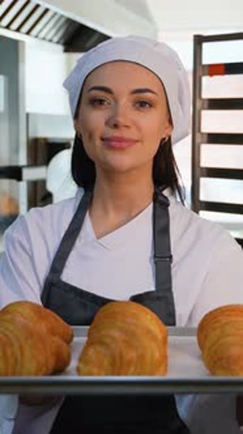 Woman Smiles Holding Tray of Fresh Croissants