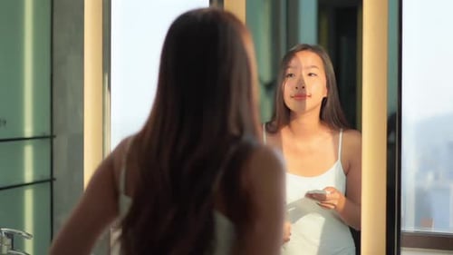 Attractive Woman Applying Lotion in Modern Bathroom