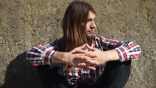 Man Long Haired Sitting Alone Sad On Grunge Wall