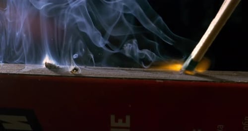 Burning matchstick close-up on a dark background. Shot on super slow motion camera 1000 fps.