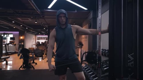 Sporty Man Trains Shoulders, Performing Side Raise Exercise in Cable Cross Over