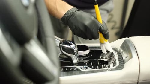 Man Detailing Car Interior with Brush Close Up