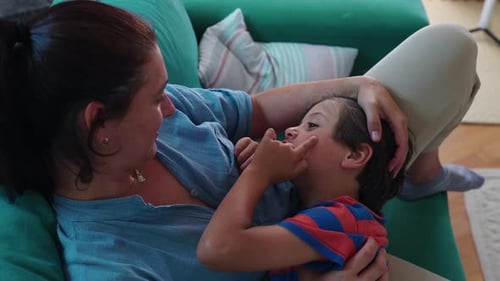 Candid Mother and Son Cuddle on Green Couch