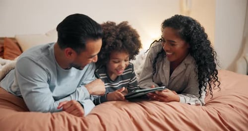 Family Lying on Bed Using Tablet Together