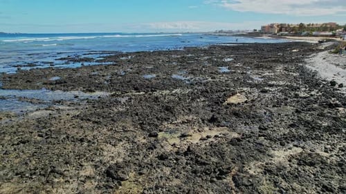 Ocean waves break on the coast of black lava of volcanic origin in Canary Islands