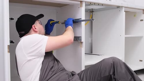 The Worker is Assembling the Design of Kitchen Furniture Installation of New Furniture