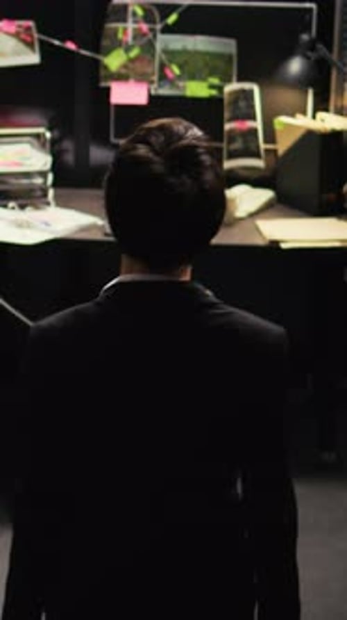 Detective Standing in Front of a Crime Board
