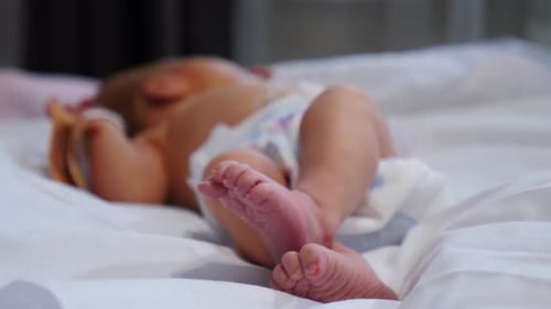 Adorable Newborn Baby Lying on White Bed