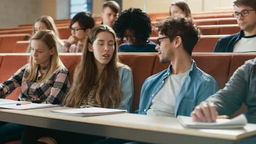 Boy and a Girl Students Talking to Each other in the University Classroom, they're Classmates Liste