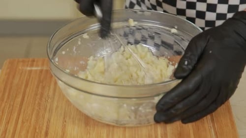 Chef professionnel écrasant le céleri-rave cuit au four tout en faisant de la purée