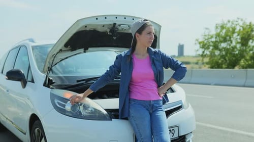Woman Leaning on Broken Down Car