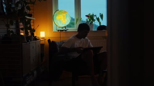 Young Adult Works Late at Home on Laptop